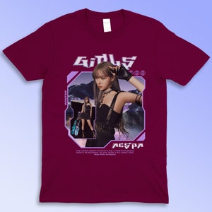 Puede incluir: Camiseta burdeos con un gr&aacute;fico de una mujer y la palabra "GIRLS" en una fuente futurista. La imagen incluye el texto "WINTER" y "AESPA". La camiseta es de la marca Gildan.