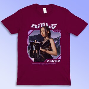 Puede incluir: Camiseta granate con un dise&ntilde;o gr&aacute;fico. El dise&ntilde;o incluye la palabra "GIRLS" en una fuente futurista, una foto de una mujer y los textos "AESPA" y "KARINA". La camiseta tambi&eacute;n tiene texto adicional.