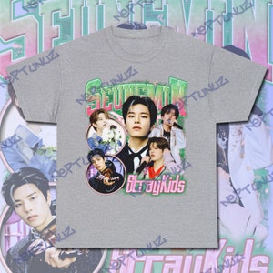Puede incluir: Camiseta gris con dise&ntilde;o retro. Presenta un collage de im&aacute;genes de un grupo musical, el nombre "SEUNGMIN" en verde y las palabras "StrayKids" en rosa. La camiseta tiene un dise&ntilde;o vintage.