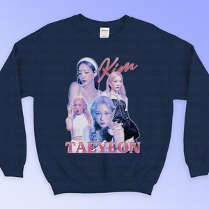 K&ouml;nnte beinhalten: Marineblaues Sweatshirt mit einer Collage von Bildern einer S&auml;ngerin, mit dem Namen "Kim Taeyeon" in rosa Schrift. Das Sweatshirt hat einen Rundhalsausschnitt und lange &Auml;rmel. Der Hintergrund ist ein Farbverlauf von Blau und Lila.