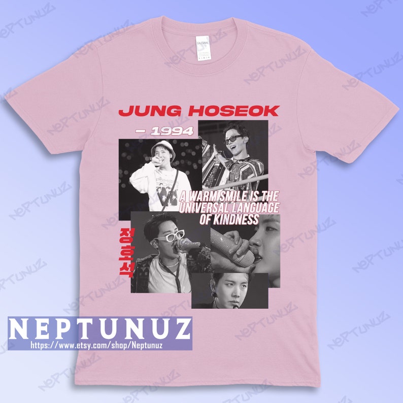 May include: Light pink t-shirt featuring a collage of black and white images of Jung Hoseok. The text "JUNG HOSEOK - 1994" is printed in red at the top. Below the images is the text "A WARM SMILE IS THE UNIVERSAL LANGUAGE OF KINDNESS".