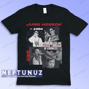 May include: Black t-shirt featuring a collage of images of Jung Hoseok, with the text "JUNG HOSEOK - 1994" in red. The shirt also includes the quote "A warm smile is the universal language of kindness" and the shop's Etsy URL.