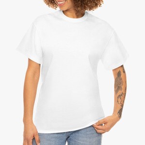 May include: A plain white t-shirt with a crew neck and short sleeves. The shirt is made of a soft, opaque material. The model is wearing blue jeans.