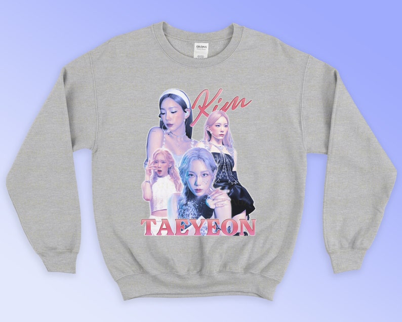 K&ouml;nnte beinhalten: Ein hellgraues Sweatshirt mit einer Collage von Bildern einer Frau, mit dem Namen "Kim" in rosa Schrift &uuml;ber den Bildern und dem Namen "Taeyeon" in rosa Blockbuchstaben darunter. Das Sweatshirt hat lange &Auml;rmel.