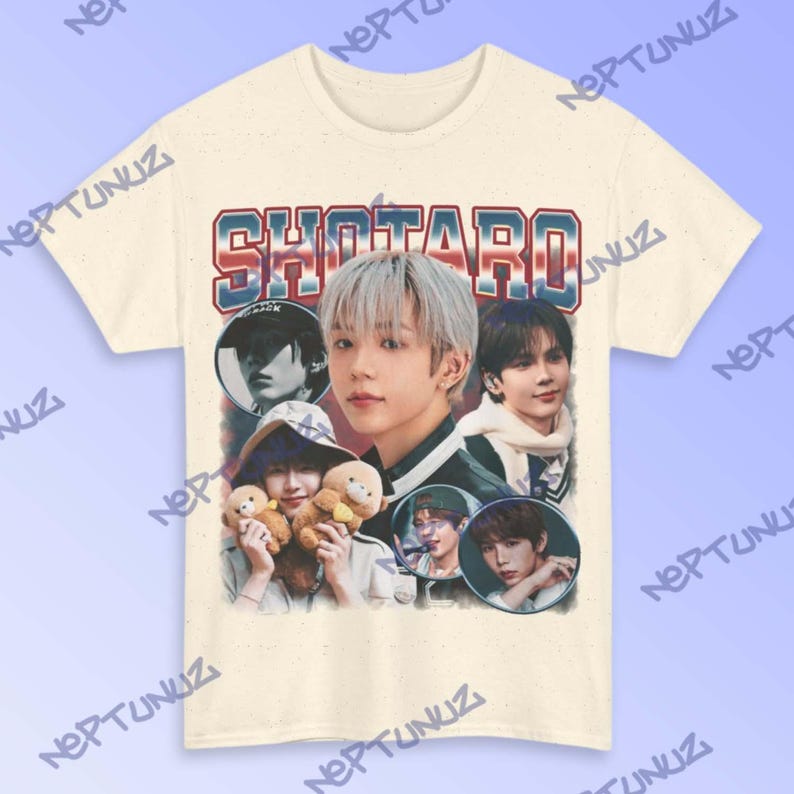 Puede incluir: Camiseta color crema con un gr&aacute;fico de estilo vintage que representa a una persona con cabello plateado y el nombre "SHOTARO" en letras rojas y azules. El dise&ntilde;o incluye m&uacute;ltiples retratos circulares y osos de peluche.