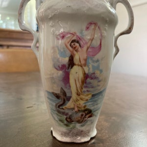 Unique porcelain vase, featuring woman happily riding a fish across the ocean