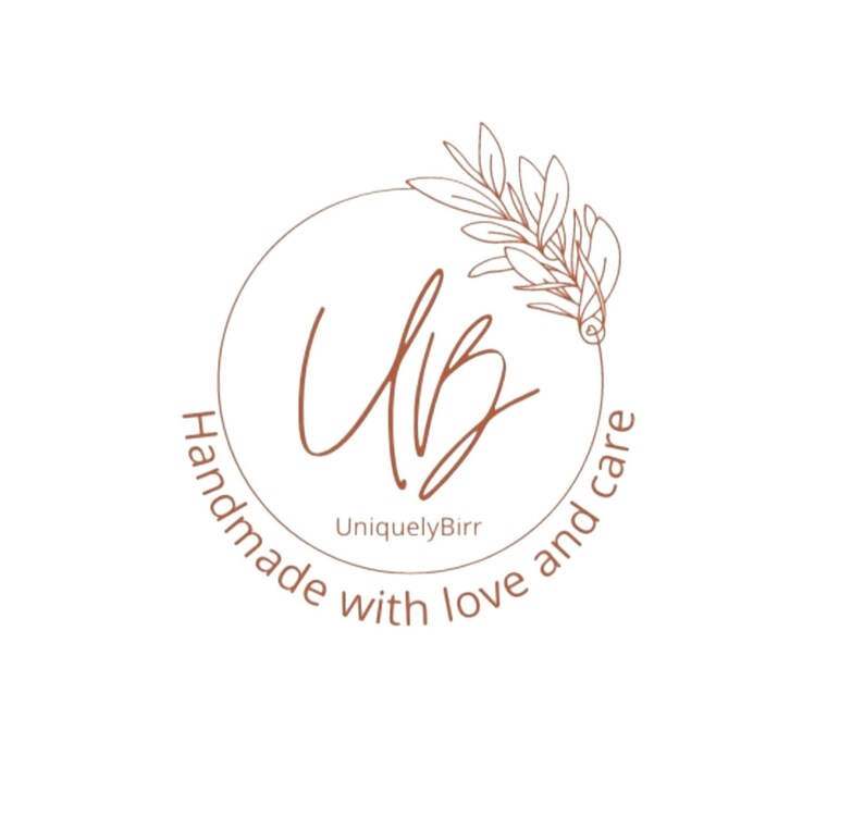 May include: A circular logo with the text "Handmade with love and care" in a brown font. The logo features the initials "UB" in a stylized script, surrounded by a brown circle and a decorative leaf design.