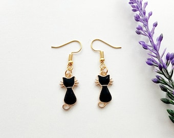 May include: A pair of gold dangle earrings with black cat charms. The cats are facing forward with their tails curled behind them.