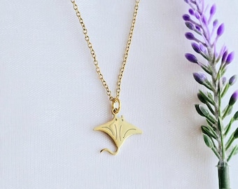 May include: A gold chain necklace with a small, detailed pendant shaped like a manta ray.