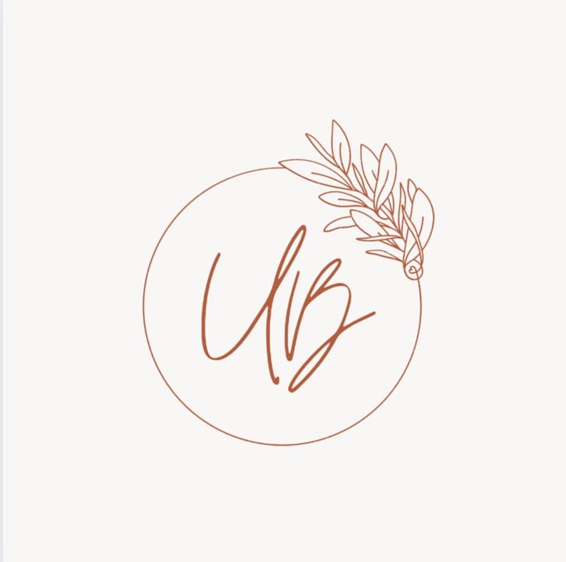 May include: A brown line drawing of a circle with the letters "UB" inside and a leafy branch with a small flower at the end on the right side of the circle.