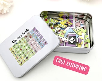 Könnte beinhalten: Eine weiße Metalldose mit einem Deckel, auf dem ein Raster mit bunten Symbolen und dem Text "AAC Core Puzzle" abgebildet ist. Der Deckel ist geöffnet und die Dose enthält einen Satz bunter Puzzle-Teile mit Symbolen darauf.
