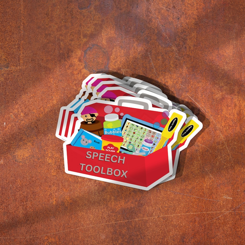 A pile of sticker that says speech toolbox is on a desk.  The image includes a red toolbox with various speech therapy toys and tools.