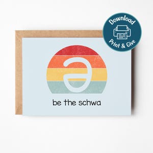 Può includere: Biglietto di auguri azzurro con un design retrò. La carta presenta un design circolare con strisce rosse, arancioni, gialle e turchesi e un simbolo schwa bianco. Il testo "be the schwa" è in basso. Una busta marrone è dietro la carta.