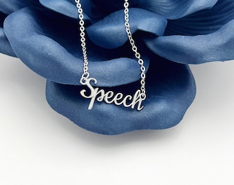 May include: A silver-colored necklace with the word "Speech" in a cursive font. The necklace is displayed on a blue background. The chain is delicate and the pendant is in a script style.
