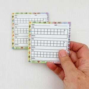 May include: Two white printable checklists with colorful borders. Each checklist has sections for name, goal, notes, and date. The checklists are designed for tracking progress.