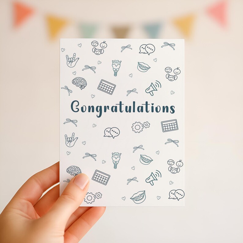 A hand holding a printable “Congratulations” card with a clean white background and SLP-themed illustrations, including AAC symbols and the ASL sign for “I love you,” ideal for celebrating new speech-language pathologists or special milestones.