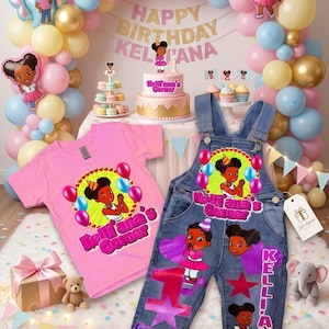 Op de afbeelding: Een roze t-shirt en een spijkerbroek met aangepaste afbeeldingen voor een verjaardag. Het shirt en de overall hebben een cartoonmeisjesontwerp, ballonnen en de tekst "Kelli'Ana's Corner". Een taart en ballonnen maken de feestelijke scène compleet.