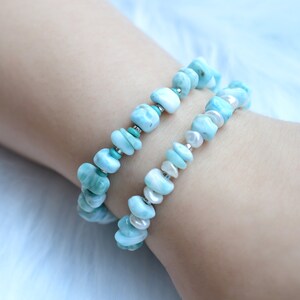 Puede incluir: Dos pulseras el&aacute;sticas con piedras Larimar azul claro pulidas e irregulares. Una pulsera est&aacute; acentuada con peque&ntilde;as cuentas turquesas, mientras que la otra se alterna con peque&ntilde;as perlas de agua dulce blancas y separadores plateados.