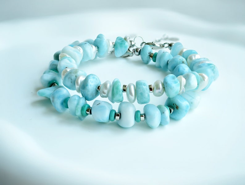 Puede incluir: Una pulsera de varias hebras con piedras preciosas pulidas de color azul claro, perlas de agua dulce blancas y peque&ntilde;as cuentas de turquesa intercaladas con espaciadores de metal plateado. Incluye un cierre de mosquet&oacute;n plateado.