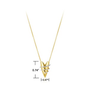 May include: A gold chain necklace with a two-tone heart pendant. The heart is made of gold and silver and has a twisted design with an arrow piercing through it. The pendant measures 0.74 inches tall and 0.47 inches wide.