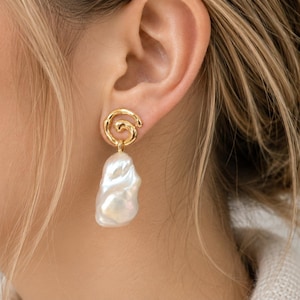 Gold spiral baroque pearl drop earrings featuring irregular creamy white pearls with natural iridescent luster, elegant statement jewelry for women