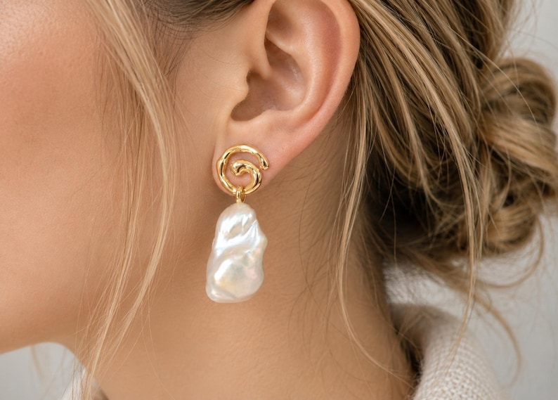 Gold spiral baroque pearl drop earrings featuring irregular creamy white pearls with natural iridescent luster, elegant statement jewelry for women
