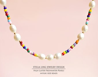 May include: A colorful beaded necklace with white freshwater pearls. The beads are in a rainbow pattern and the pearls are large and lustrous. The necklace is made by Stella Ling Jewelry Design.