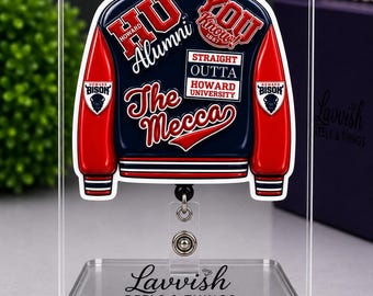 May include: A Howard University varsity jacket badge reel featuring a navy blue and red design with text including HU Alumni, You Know, Straight Outta Howard University, and The Mecca. The badge reel is displayed on a clear acrylic stand.