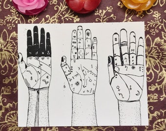 Könnte beinhalten: Eine weiße Karte mit drei Handillustrationen, jede mit detaillierten schwarzen Linien, die Handlesesymbole darstellen. Darüber liegen drei blütenförmige Kerzen in Rosa, Rot und Orange auf einem gemusterten Hintergrund.