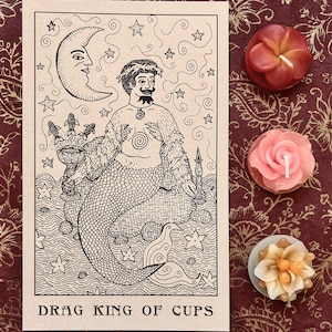 May include: A tarot card illustration of the Drag King of Cups. The card features a merman with a beard and a crown of seaweed, holding a cup with corn cobs in it. The background is a starry night sky with a crescent moon.
