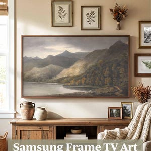 May include: A living room interior with a large landscape painting in a wooden frame above a cabinet. The cabinet displays vases and books. Framed botanical prints and dried flowers are also on the wall. The text "Samsung Frame TV Art" is visible.