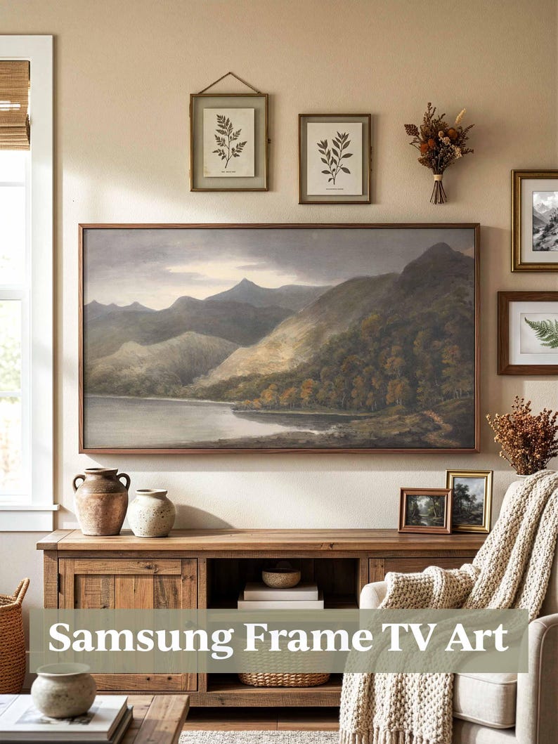 May include: A living room interior with a large landscape painting in a wooden frame above a cabinet. The cabinet displays vases and books. Framed botanical prints and dried flowers are also on the wall. The text "Samsung Frame TV Art" is visible.