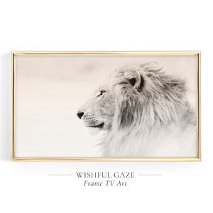May include: A rectangular wall art piece featuring a black and white profile portrait of a lion with a thick mane, enclosed in a thin gold frame. Below the image, the text reads WISHFUL GAZE Frame TV Art in a clean, centered font style.