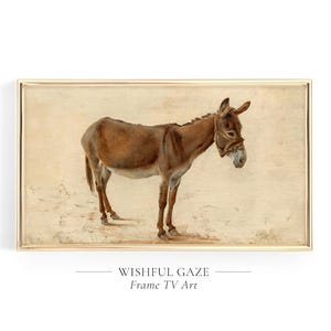 May include: A painting of a brown donkey standing on a beige background. The donkey is looking off to the side with a wistful expression. The painting is framed in a gold frame.