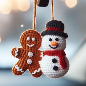 Könnte beinhalten: Ein gehäkelter Lebkuchenmann und Schneemann, die an einem Rückspiegel hängen. Der Lebkuchenmann ist braun mit weißem Zuckerguss und der Schneemann ist weiß mit einem roten Schal und schwarzen Knöpfen.