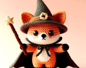 May include: A crocheted orange fox wearing a black witch hat with a brown brim and a brown and white star-shaped wand. The fox is wearing a black cape and has a white belly.