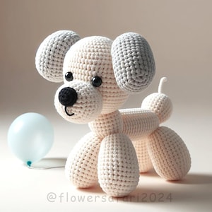 Peut inclure: Un jouet en peluche en forme de chien crocheté avec des oreilles grises, des yeux noirs et un nez noir. Le chien est assis, les pattes tendues. Le chien est fait d'un fil blanc doux.