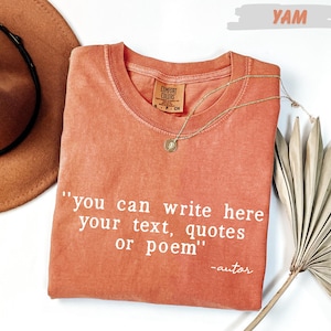 a red t-shirt with a quote printed on it, along with a hat and a fan, all placed on a white background.