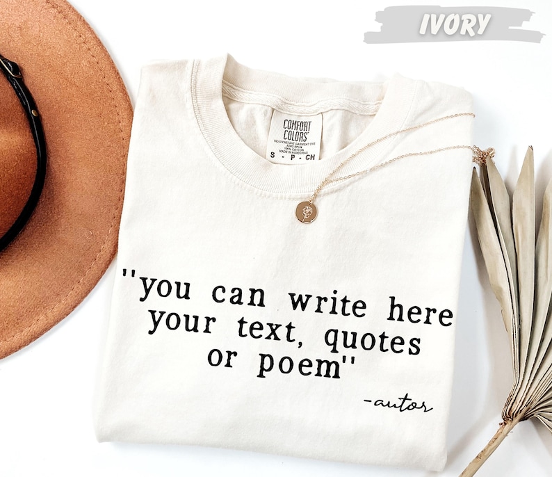 a white t-shirt with a quote printed on it, along with a brown hat and a plant.