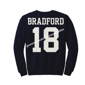 May include: Navy blue sweatshirt with white text that reads "BRADFORD 18" on the back.