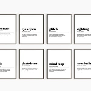 May include: Eight framed art prints with black frames and white backgrounds. Each print features a word in bold black text, such as "hidden tapes" or "glitch", along with a definition. The prints are arranged in two rows of four.