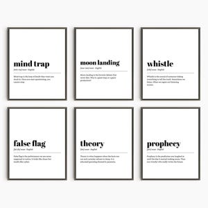 May include: Six framed prints with black frames and white backgrounds. Each print features a word in bold black text, such as "mind trap" and "moon landing", along with a definition. The prints are arranged in two rows of three.