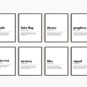 May include: Eight framed prints with black frames and white backgrounds. Each print features a word in bold black text, such as "whistle" or "false flag", with a definition below. The prints are arranged in two rows of four.