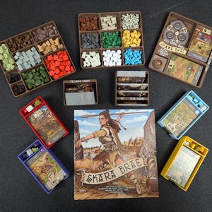 Könnte beinhalten: Ein Brettspiel namens "Skara Brae" mit verschiedenen Komponenten, darunter Holzfiguren, Karten und ein Spielbrett. Das Spielbrett ist braun mit einem beigefarbenen Rand und zeigt eine Karte eines Dorfes. Die Spielfiguren sind aus Holz und in verschiedenen Farben bemalt, darunter Rot, Grün, Blau und Gelb. Die Karten sind aus Pappe und mit Illustrationen von Gebäuden und Menschen bedruckt. Das Spiel ist für 2-4 Spieler konzipiert.