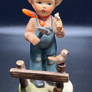 Vintage Giftcraft made in Japan.  German boy fixing fence with hammer, has a bandaged finger.