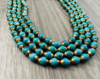 May include: A multi-strand necklace made of turquoise and gold beads. The beads are round and have a smooth finish. The necklace is a beautiful shade of blue and gold.