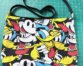 Bolso bandolera grande reciclado hecho a mano con correa ajustable, múltiples bolsillos y estampado de dibujos animados.