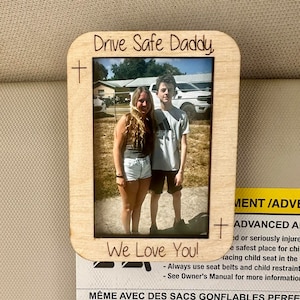 May include: A wooden photo frame with a picture of two people standing outside. The frame has the text "Drive Safe Daddy" and "We Love You!" printed on it.