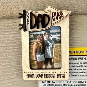 May include: A wooden photo frame with a banner that reads "Best Dad Ever". The frame has a photo of two people, a girl and a boy, standing in front of a truck. The text "Happy Father's Day 2024 From Your Biggest Fans!" is printed on the frame.
