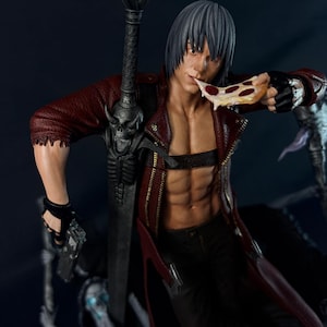 Peut inclure: Une figurine de collection détaillée représentant un personnage aux cheveux gris courts, vêtu d'une veste en cuir rouge et d'un pantalon noir. La figurine tient une part de pizza au pepperoni à la bouche et porte une grande épée à garde crânienne.